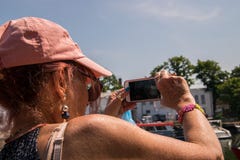 Baby boomer de femme utilisant la casquette de baseball rose prenant la photo d'a images stock Baby boomer de femme utilisant la casquette de baseball rose prenant la photo d'a images stock