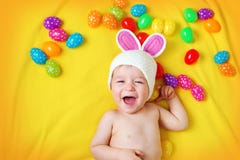 Baby boy in bunny hat lying on yellow blanket with easter eggs Stock Images Baby boy in bunny hat lying on yellow blanket with easter eggs Stock Images
