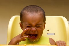 Baby boy crying while eating stock image Baby boy crying while eating stock image