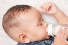 Baby Boy Holding Milk Bottle Stock Photography