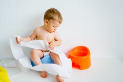 Baby, das auf einem Töpfchen sitzt Stockbild Baby, das auf einem Töpfchen sitzt Stockbild