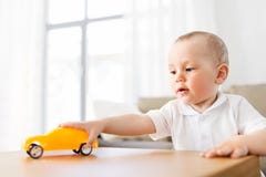 Baby, das zu Hause mit Spielzeugauto spielt lizenzfreies stockbild Baby, das zu Hause mit Spielzeugauto spielt lizenzfreies stockbild