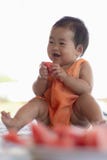 Baby eating water melon and smile.