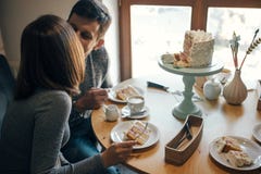Baby gender reveal party. Happy stylish pregnant couple eating delicious cream cake at baby shower, with pink cream inside. Happy stock images Baby gender reveal party. Happy stylish pregnant couple eating delicious cream cake at baby shower, with pink cream inside. Happy stock images