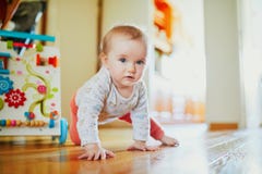 Baby Girl Learning To Crawl Stock Images