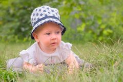 Happy childhood concept. Baby girl in hat, panama. Toddler lying in the grass. stock images Happy childhood concept. Baby girl in hat, panama. Toddler lying in the grass. stock images