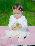Baby in heldere kleren op een roze plaid op groen gras in het park stock fotografie Baby in heldere kleren op een roze plaid op groen gras in het park stock fotografie