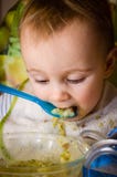 Baby isst Brei mit Brot von einer Glasplatte Stockbild Baby isst Brei mit Brot von einer Glasplatte Stockbild