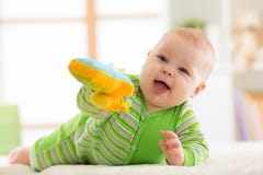 Baby lying on her belly with toy on a bed at home royalty free stock photos Baby lying on her belly with toy on a bed at home royalty free stock photos