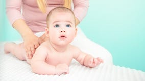 Baby Massage Background. Young Therapist Giving A Baby Boy A Back Massage. Royalty Free Stock Photos