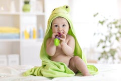 Baby met groene handdoek na het bad het bijten stuk speelgoed royalty-vrije stock fotografie Baby met groene handdoek na het bad het bijten stuk speelgoed royalty-vrije stock fotografie