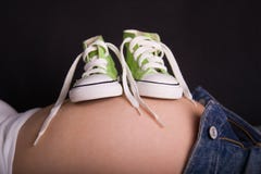 Baby shoes on pregnant belly