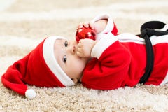 Baby weared hollding Weihnachtsball Sankt lizenzfreies stockbild Baby weared hollding Weihnachtsball Sankt lizenzfreies stockbild