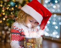 Babymeisje die een magische giftdoos openen Royalty-vrije Stock Fotografie Babymeisje die een magische giftdoos openen Royalty-vrije Stock Fotografie