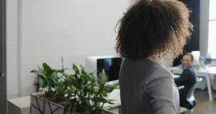 Back rear view of African American business woman coming to modern office holding bicycle stock video footage Back rear view of African American business woman coming to modern office holding bicycle stock video footage