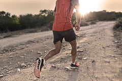 Sport man with ripped athletic and muscular legs running uphill off road in jogging training workout stock photos Sport man with ripped athletic and muscular legs running uphill off road in jogging training workout stock photos