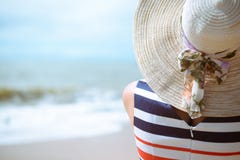 Back view of elegant beautiful woman in dress and straw hat on the beach. royalty free stock photos Back view of elegant beautiful woman in dress and straw hat on the beach. royalty free stock photos