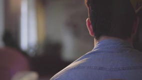 Back view of the man in birthday hat in an empty room. Nobody comes to the party, the guy sad and disappointed. Concept stock video Back view of the man in birthday hat in an empty room. Nobody comes to the party, the guy sad and disappointed. Concept stock video