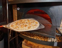 Backenpizza in den traditionellen Holzofen Lizenzfreies Stockbild Backenpizza in den traditionellen Holzofen Lizenzfreies Stockbild