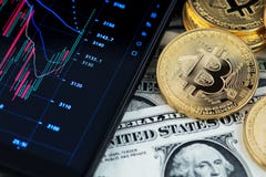 Bitcoin cryptocurrency and banknotes of one US dollar next to mobile phone showing candlestick chart. royalty free stock photo Bitcoin cryptocurrency and banknotes of one US dollar next to mobile phone showing candlestick chart. royalty free stock photo