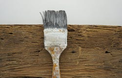 Paint brushes placed on an old wooden board.