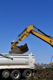 Backhoe сбрасывает грязь в коробке тележки стоковые изображения rf Backhoe сбрасывает грязь в коробке тележки стоковые изображения rf