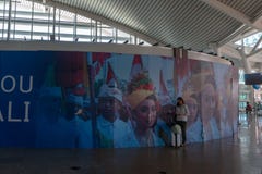 BADUNG/BALI- 28 MARZO 2019: Un turista femminile, portante una valigia, stava stando in un'area in un aeroporto ornamentale di ba fotografia stock BADUNG/BALI- 28 MARZO 2019: Un turista femminile, portante una valigia, stava stando in un'area in un aeroporto ornamentale di ba fotografia stock