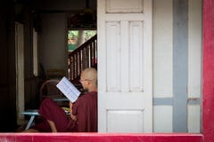Bagan Myanmar - 24 Juli 2014: Den lokala Burmese munken sitter förbi arkivfoto Bagan Myanmar - 24 Juli 2014: Den lokala Burmese munken sitter förbi arkivfoto