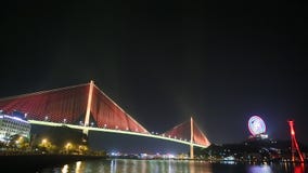 The Bai Chay Bridge in Ha Long, Vietnam lit up with colorful lighting at night. stock video footage The Bai Chay Bridge in Ha Long, Vietnam lit up with colorful lighting at night. stock video footage