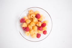 Baies des framboises rouges et jaunes, cassis dans une cuvette brune sur l'herbe Compote des baies photographie stock libre de droits Baies des framboises rouges et jaunes, cassis dans une cuvette brune sur l'herbe Compote des baies photographie stock libre de droits