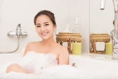 Baigner la femme détendant dans la détente de sourire de bain Jeune femme asiatique dans la baignoire image libre de droits Baigner la femme détendant dans la détente de sourire de bain Jeune femme asiatique dans la baignoire image libre de droits
