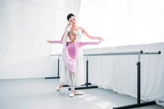 bailarina pequena adorável no tutu cor-de-rosa que exercita com professor fotografia de stock bailarina pequena adorável no tutu cor-de-rosa que exercita com professor fotografia de stock