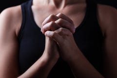 Baixa chave, fim acima das mãos de rezar fiel da mulher fotografia de stock Baixa chave, fim acima das mãos de rezar fiel da mulher fotografia de stock