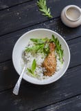 Bakad höna, ris och sallad i en bunke på en mörk träbakgrund arkivfoto Bakad höna, ris och sallad i en bunke på en mörk träbakgrund arkivfoto