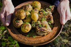 Baked potatoes with pork ribs on the fire laid out on a clay plate, decorated with greens. Dinner in nature stock photography Baked potatoes with pork ribs on the fire laid out on a clay plate, decorated with greens. Dinner in nature stock photography