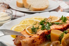 Baked salmon fillet medallion with salad of pickled vegetables and mushrooms on a white plate on a gray background, close up royalty free stock photo Baked salmon fillet medallion with salad of pickled vegetables and mushrooms on a white plate on a gray background, close up royalty free stock photo