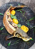 Baked sturgeon fish with rosemary, lemon and passion fruit on plate on wooden background close up royalty free stock photos Baked sturgeon fish with rosemary, lemon and passion fruit on plate on wooden background close up royalty free stock photos