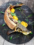 Baked sturgeon fish with rosemary, lemon and passion fruit on plate on wooden background close up. royalty free stock images Baked sturgeon fish with rosemary, lemon and passion fruit on plate on wooden background close up. royalty free stock images