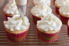 Baker διακοσμεί muffins με τα ακροφύσια κρέμας και βιομηχανιών ζαχαρωδών προϊόντων στοκ εικόνες με δικαίωμα ελεύθερης χρήσης Baker διακοσμεί muffins με τα ακροφύσια κρέμας και βιομηχανιών ζαχαρωδών προϊόντων στοκ εικόνες με δικαίωμα ελεύθερης χρήσης