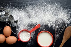 Baking ingredients on a dark, stone table: eggs, flour and milk royalty free stock image Baking ingredients on a dark, stone table: eggs, flour and milk royalty free stock image