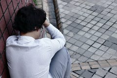 Bakre sikt av den frustrerade utmattade asiatiska affärsmannen i fördjupning med händer på pannan royaltyfri foto Bakre sikt av den frustrerade utmattade asiatiska affärsmannen i fördjupning med händer på pannan royaltyfri foto