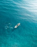 Balena che gira nell'oceano Colpo aereo di una balena che viola la cima dell'acqua dell'oceano blu immagini stock Balena che gira nell'oceano Colpo aereo di una balena che viola la cima dell'acqua dell'oceano blu immagini stock