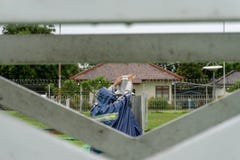 BALI/INDONESIA-DECEMBER 21 2017: Meteorologiczny obserwator sprawdza Helman deszczu metr przy meteorologia ogródem upewniać si zdjęcie stock BALI/INDONESIA-DECEMBER 21 2017: Meteorologiczny obserwator sprawdza Helman deszczu metr przy meteorologia ogródem upewniać si zdjęcie stock