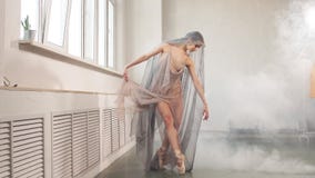 Ballerina in flying dress flexing her leg preparing to performance on stage. stock video footage Ballerina in flying dress flexing her leg preparing to performance on stage. stock video footage