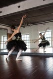 Ballerina πρόβας στην αίθουσα Άσπροι τοίχοι, σκοτεινό ξύλινο πάτωμα, σκοτεινό ανώτατο όριο, όμορφοι πολυέλαιοι, Η αντανάκλαση στοκ φωτογραφίες με δικαίωμα ελεύθερης χρήσης Ballerina πρόβας στην αίθουσα Άσπροι τοίχοι, σκοτεινό ξύλινο πάτωμα, σκοτεινό ανώτατο όριο, όμορφοι πολυέλαιοι, Η αντανάκλαση στοκ φωτογραφίες με δικαίωμα ελεύθερης χρήσης
