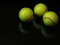 Balles de tennis d'arbre sur le fond noir foncé image stock Balles de tennis d'arbre sur le fond noir foncé image stock