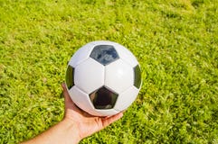 Ballon de football à disposition de joueur de football sur l'herbe verte photo stock Ballon de football à disposition de joueur de football sur l'herbe verte photo stock