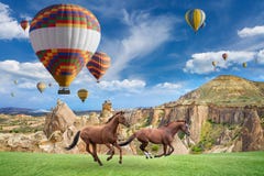 Ballongflygande för varm luft och två hästar som kör i Cappadocia, Turkiet arkivbild Ballongflygande för varm luft och två hästar som kör i Cappadocia, Turkiet arkivbild