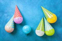 Ballons drôles colorés dans des chapeaux sur la vue supérieure bleue de table Concept créatif pour le fond de fête d'anniversaire photos libres de droits Ballons drôles colorés dans des chapeaux sur la vue supérieure bleue de table Concept créatif pour le fond de fête d'anniversaire photos libres de droits