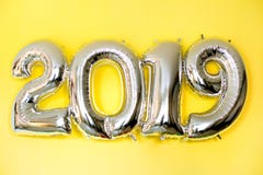 Ballons gonflables argentés sous forme de numéros 2019 sur le fond jaune images stock Ballons gonflables argentés sous forme de numéros 2019 sur le fond jaune images stock